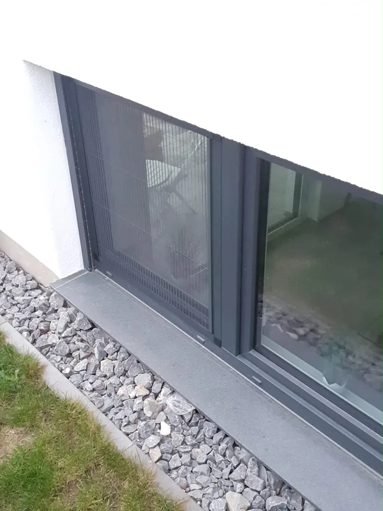 Seitliche Ansicht eines Insektenschutz-Plissees an einem bodennahen Fenster