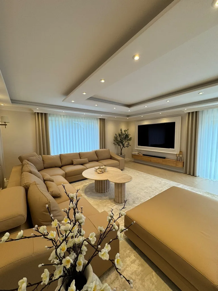 Weiße Wellengardinen und beige Seitenschals im Wohnzimmer mit beiger Wohnlandschaft