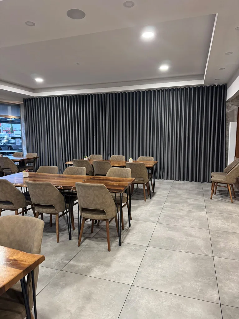 Bodenlange graue Wellenvorhänge als textile Wandgestaltung in einem Restaurant