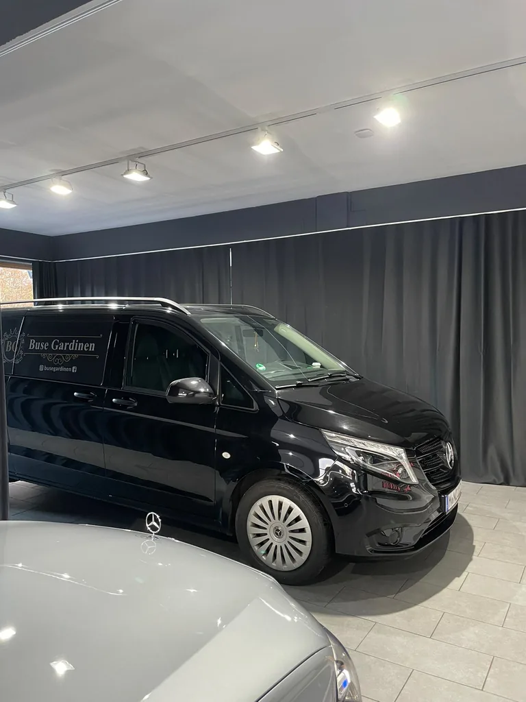 Dunkelgraue Vorhänge im Autohaus hinter dem Fahrzeug von Buse Gardinen